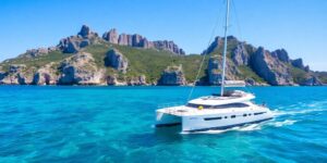Catamaran sailing on clear blue Sardinian waters.