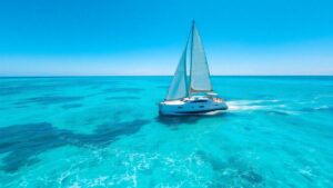 Private sailboat on turquoise water under a sunny sky.