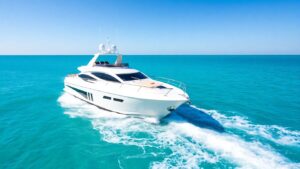 Luxury yacht sailing on calm turquoise ocean waters.