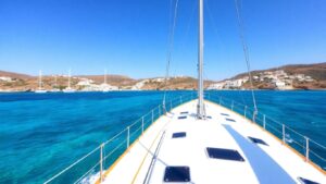 Sailboat sailing in Greece with islands in background.