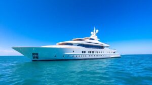 Opulent luxury yacht sailing on a calm turquoise ocean.