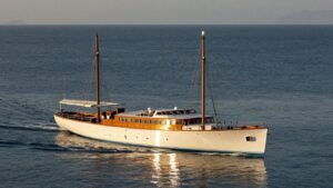 Elegant 1920s yacht on a calm, sunlit ocean.