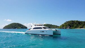 Catamaran sailing in clear turquoise Bahamian waters.