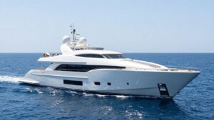 Elegant superyacht sailing on a clear blue sea.