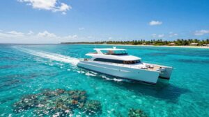 Catamaran sailing on turquoise Caribbean waters near islands.