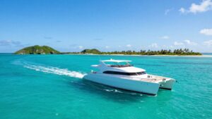Catamaran sailing in clear Bahamian waters near islands.