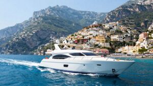 Luxury yacht sailing Amalfi Coast waters with scenic cliffs.