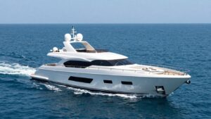 Luxurious 80m superyacht sailing on a clear blue ocean.