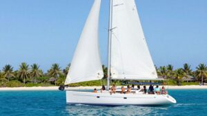 Luxury sailboat cruising near tropical islands and blue water.