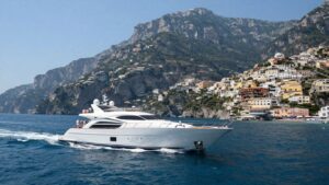 Luxury yacht sailing Amalfi Coast with colorful villages.