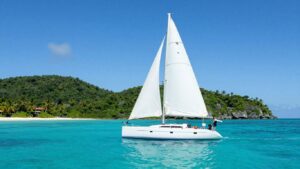 Sailboat sailing in the BVI with islands in background.