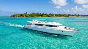 Catamaran sailing in clear Caribbean waters near islands.