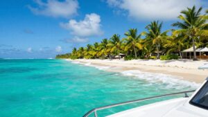 Catamaran sailing on turquoise Caribbean waters near islands.