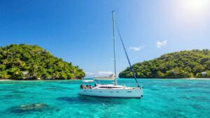 Sailboat on turquoise water near Belize islands.
