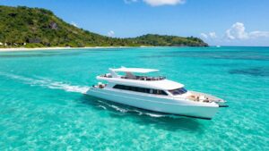 Catamaran sailing in clear Caribbean waters near islands.