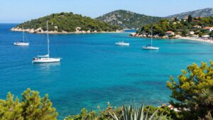 Boats sailing on clear blue water near Croatian islands.