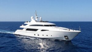 Luxurious superyacht sailing on a bright blue ocean.
