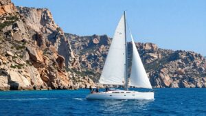 Sailboat on turquoise Mediterranean waters near Sardinia.