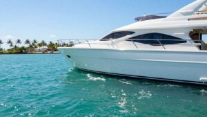 Luxury yacht sailing on Florida waters with palm trees.
